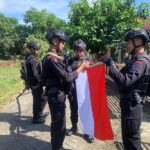 Brimob Bone Bantu Warga Pasang Bendera Merah Putih 