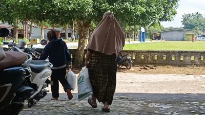 Warga Desa Bontonyeleng menerima bantuan beras Bulog di kantor desa