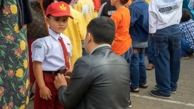 Ayah sedang mengantar anaknya ke sekolah di hari pertama tahun ajaran baru di Bulukumba.