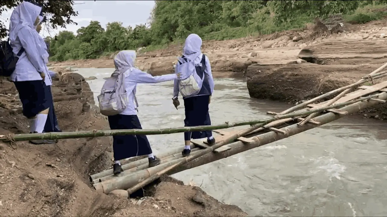 Siswa sekolah saat melintasi jembatan darurat dari bambu di Desa Bialo Bulukumba.