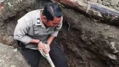 Aiptu Jusman anggota Polsek Gantarang bantu warga gali kubur di Desa Padang.