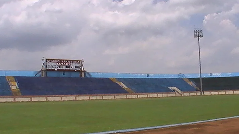 Tribun biru dan papan skor lama Stadion Kanjuruhan Kepanjen dilihat dari lapangan