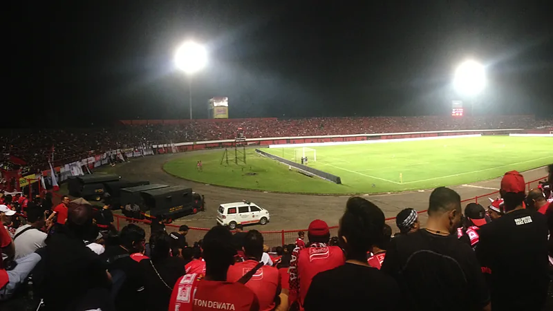 Suporter berbaju merah memadati tribun Stadion Kapten I Wayan Dipta saat laga malam dengan lampu sorot menyala