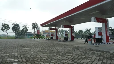 Area pengisian SPBU Pertamina berkanopi merah dengan pompa Premium dan Biosolar di bawah langit mendung