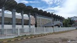 Stadion Segiri Samarinda dengan atap tribun melengkung berderet, pagar putih, dan papan nama di fasad bermotif