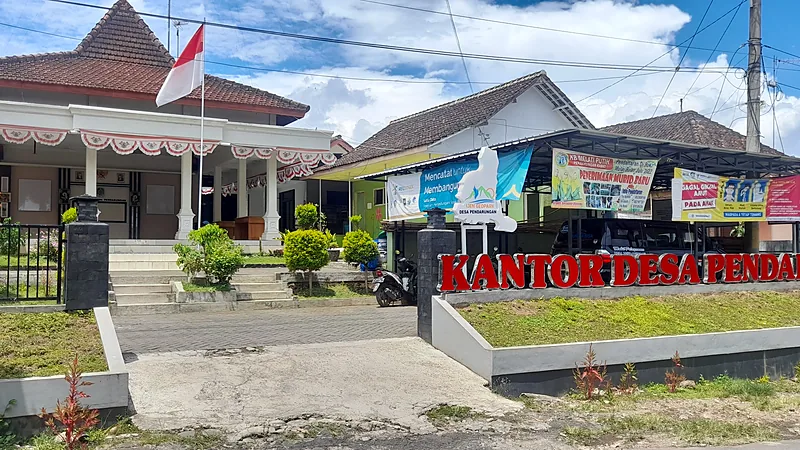 Cabjari Kajang Sebar QR Laporkan Korupsi ke Lima Desa Kantor Desa Pendarungan dengan tulisan besar berwarna merah, tiang bendera, dan spanduk layanan desa
