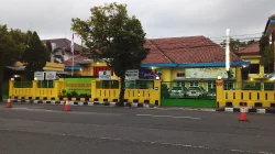 Kompleks kantor Kejaksaan Negeri Kebumen bercat kuning dan hijau di tepi jalan raya beraspal