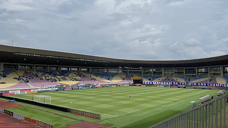 Championship Tetap Bergulir Saat Super League Jeda FIFA Lapangan Stadion Manahan dilihat dari tribun atas dengan kursi berwarna kuning dan ungu serta papan iklan mengelilingi lapangan