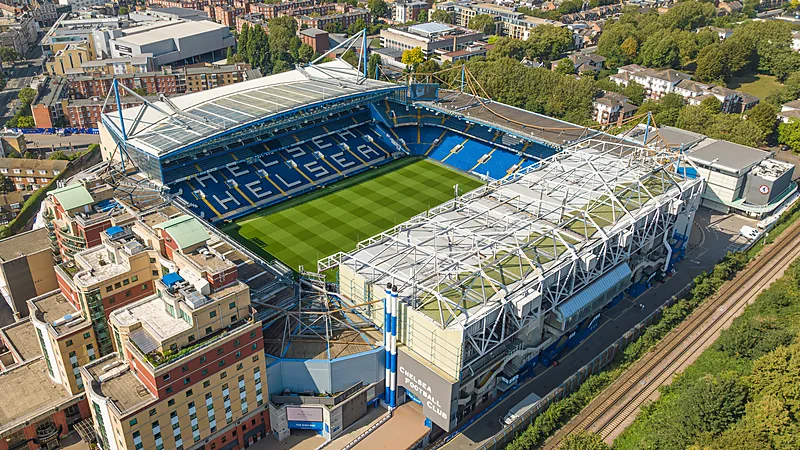 Chelsea Ditahan Hull City 2-2, Belloumi Dua Gol di Stamford Bridge Foto udara Stamford Bridge memperlihatkan lapangan hijau dan tribun biru di tengah permukiman London