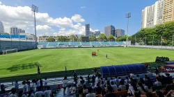 Lapangan dan tribune Stadion Jalan Besar Singapura pada siang hari dengan gedung tinggi di latar belakang