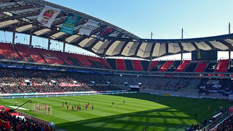 Pertandingan FC Seoul di Seoul World Cup Stadium dengan tribun merah dan penonton di bawah atap