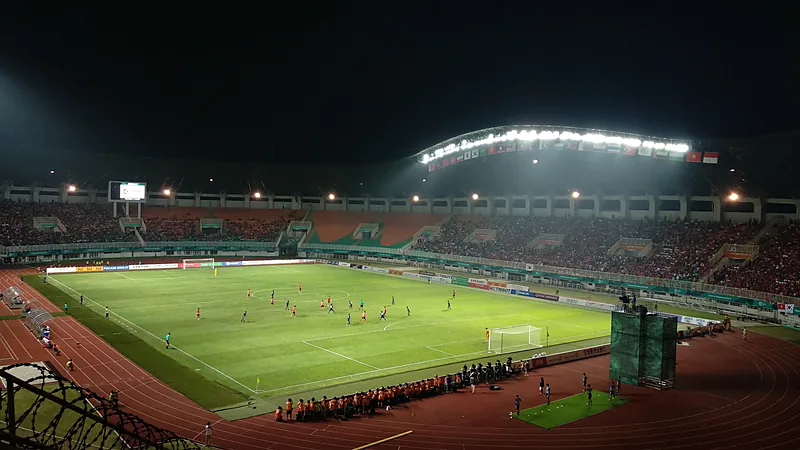 Pertandingan malam hari di Stadion Pakansari dengan tribun penuh penonton