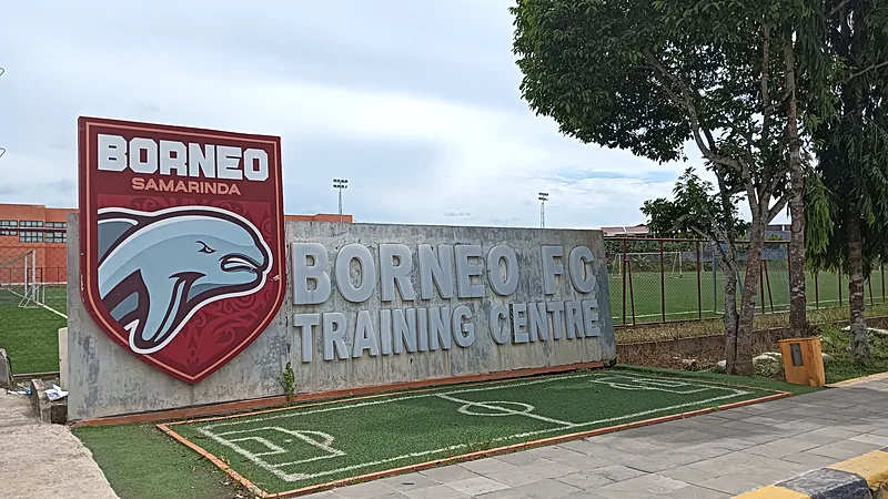 Papan nama Borneo FC Training Centre dengan logo klub di depan lapangan latihan