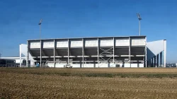 Tribun Stadion Fortuna Sittard dilihat dari luar dengan dua tiang lampu di bawah langit biru