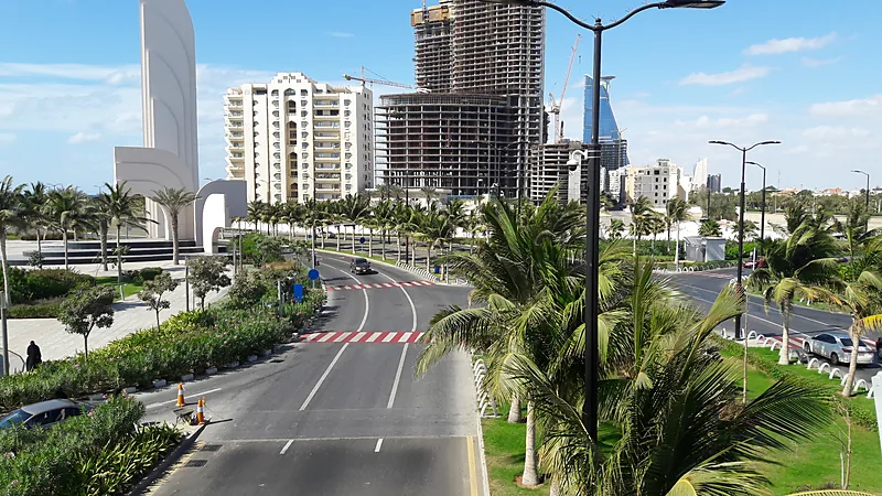 Saudi Cegat Drone Dekat Makkah, Kemlu Minta WNI Ikuti Instruksi Resmi Jalan raya di kawasan Corniche Jeddah dengan pohon palem, gedung apartemen, dan bangunan tinggi yang sedang dibangun