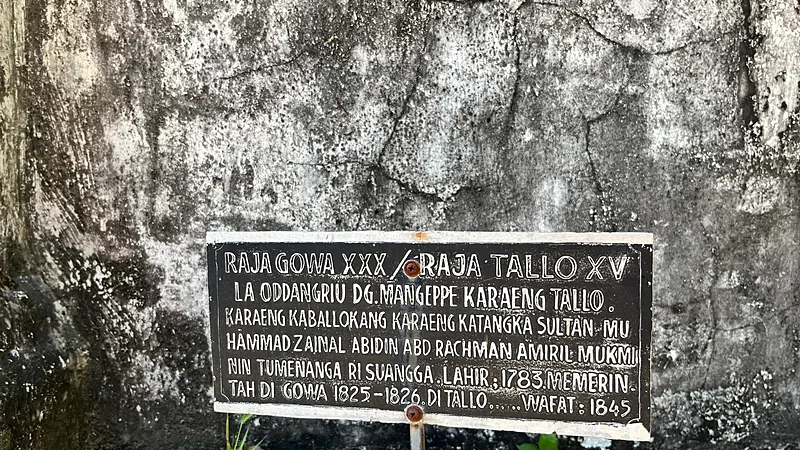 Jejak Kerajaan Lama di Bulukumba dan 86 Cagar Budaya Papan penanda makam berwarna hitam berhuruf putih bertuliskan Raja Gowa XXX atau Raja Tallo XV La Oddangriu Dg Mangeppe, terpasang di depan dinding batu berlumut