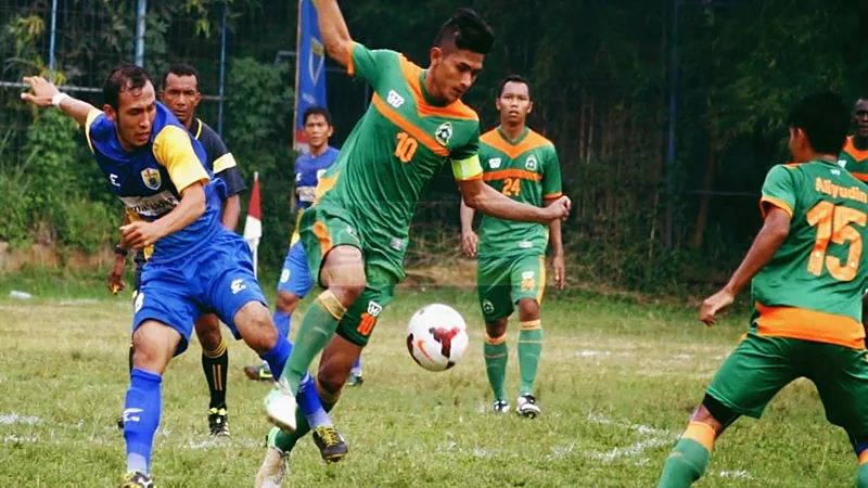 Klasemen BRI Super League 2026/27 Usai Pekan 2: Bali United Teratas Ilustrasi pemain berkostum hijau oranye dan biru kuning berebut bola di lapangan rumput