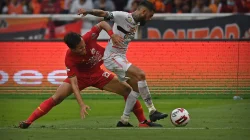 Pemain Persija Jakarta berkostum merah berduel merebut bola dengan pemain lawan berkostum putih di lapangan