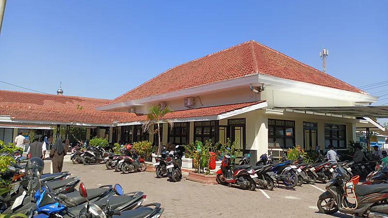 Cara Urus KTP-el dan Akta Kelahiran di Bulukumba Halaman kantor kecamatan beratap genteng merah penuh sepeda motor terparkir, beberapa warga berjalan menuju pintu layanan di bawah langit cerah