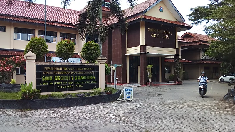 Gedung utama SMK Negeri 1 Gombong dengan papan nama sekolah di halaman berpaving