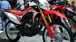Sepeda motor trail Honda CRF150L berwarna merah dan putih dipajang di ruang pameran otomotif