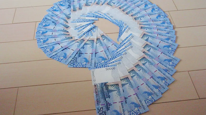 Perubahan APBD Sulsel 2026 Lanjut ke Komisi, PAD Turun Rp235 Miliar Lembaran uang pecahan Rp50.000 disusun melingkar di atas lantai kayu