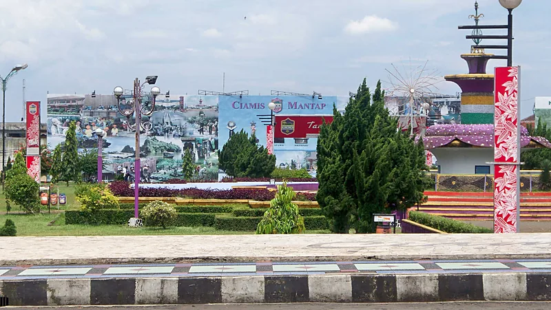 Taman Alun-alun Ciamis dengan pohon cemara, lampu taman, dan baliho bertuliskan Ciamis Mantap