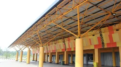Kanopi kuning Stadion Kaharuddin Nasution Pekanbaru dengan pilar oranye di area pintu masuk
