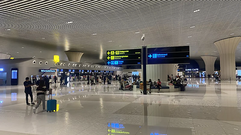Ruang terminal Bandara Internasional Sultan Hasanuddin dengan papan petunjuk pelaporan, keberangkatan, dan informasi