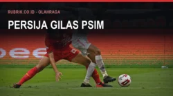 Pemain berkostum merah Persija menahan laju pemain lawan berkostum abu-abu di dekat bola, dengan teks judul "Persija Gilas PSIM" dan label Rubrik.co.id - Olahraga di bagian atas gambar